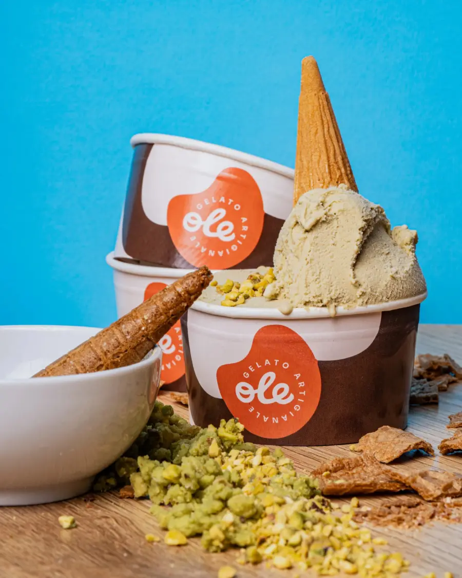 Coppette Gelateria Piacevole con gelato al pistacchio e granella su fondo azzurro