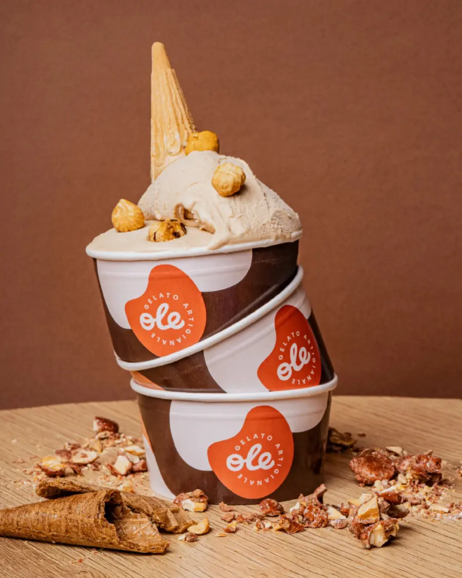 Content creation gelateria: tre coppette Piacevole impilate con gelato alla nocciola e cono